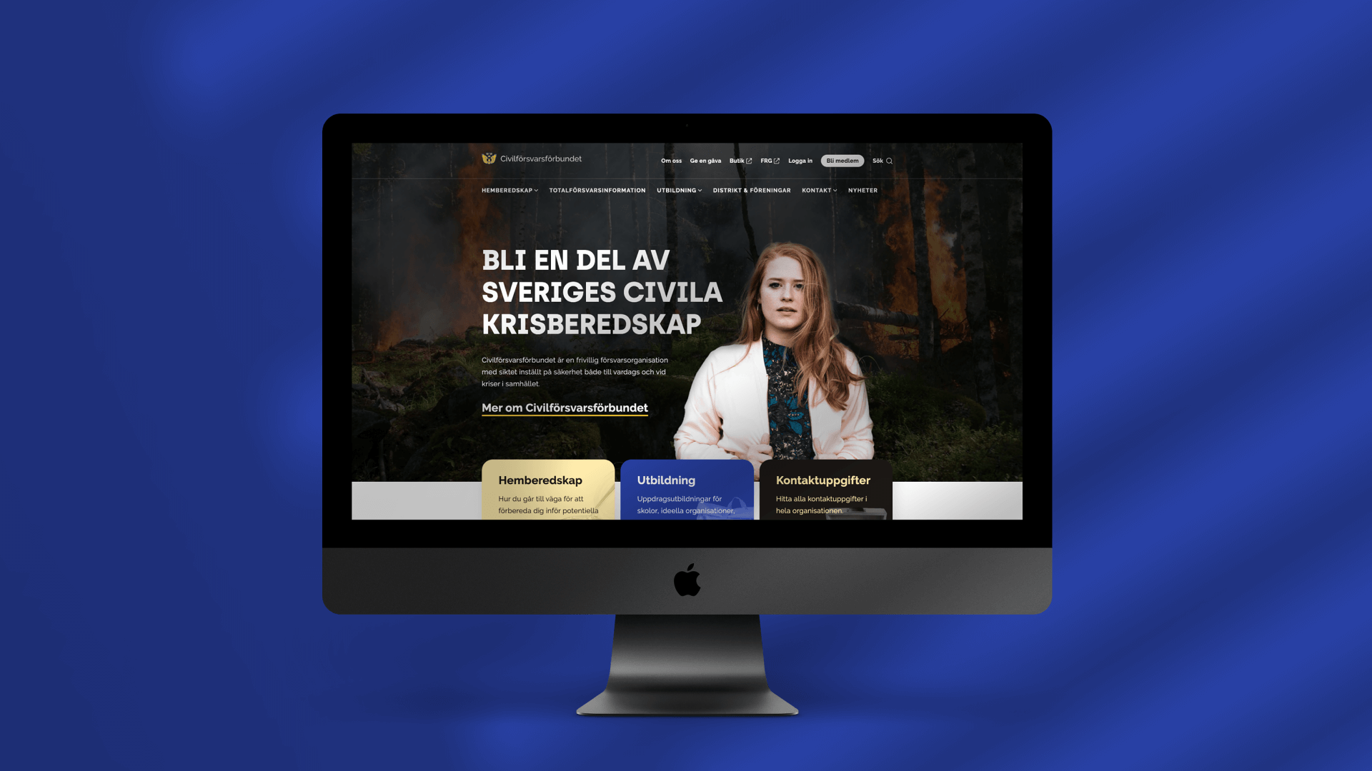 Civilförsvarets startsida visas på en iMac mot en blå bakgrund med mönster av skuggor.